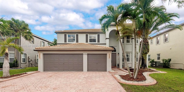 mediterranean / spanish home featuring a garage and a front lawn