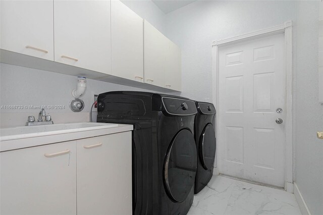 washroom featuring washer and clothes dryer, cabinets, and sink