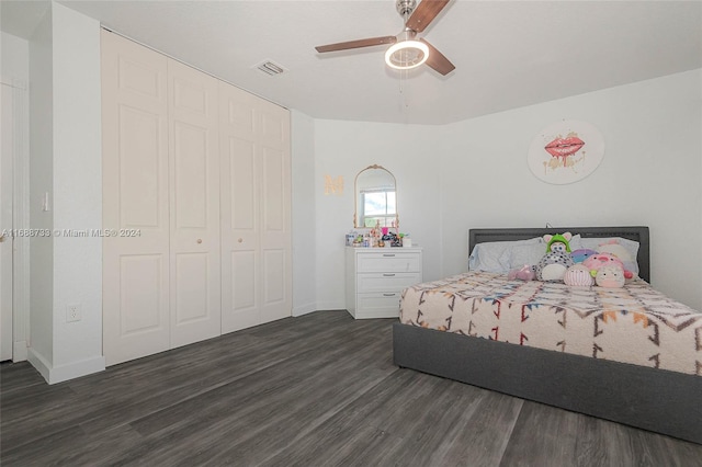 bedroom with dark wood-type flooring, ceiling fan, and a closet