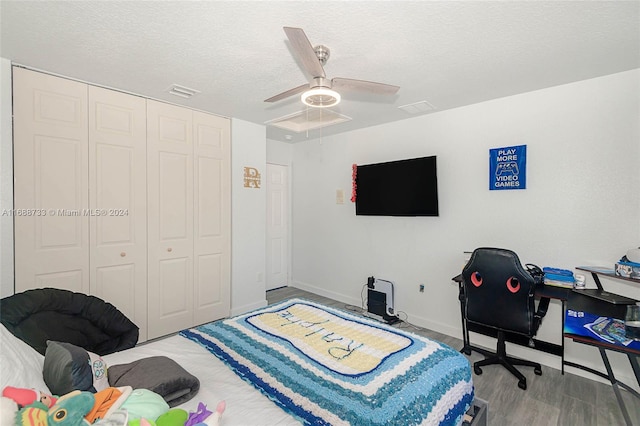 bedroom featuring a closet, a textured ceiling, ceiling fan, and light hardwood / wood-style flooring