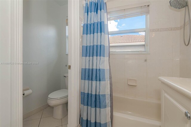 bathroom with tile patterned flooring, toilet, and shower / bath combination with curtain