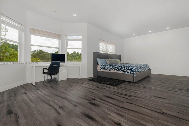 bedroom featuring dark wood-type flooring and built in desk