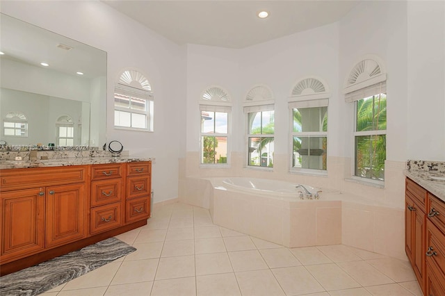 bathroom featuring a relaxing tiled tub, tile patterned floors, and vanity