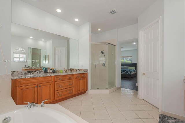 bathroom featuring tile patterned flooring, an enclosed shower, and vanity