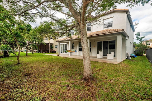 rear view of house with a patio and a yard