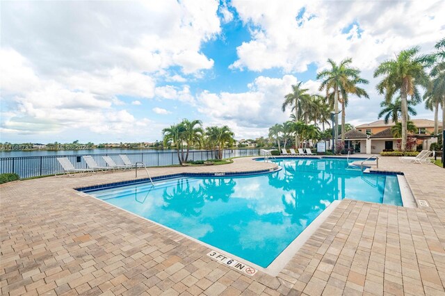 view of swimming pool featuring a patio and a water view