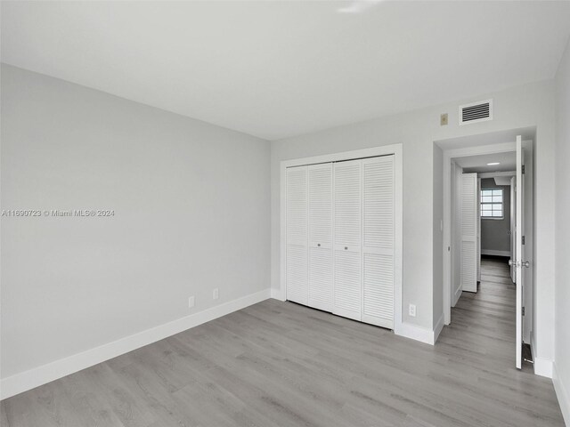 3700 Oaks Clubhouse Dr Unit 203, Pompano Beach, FL 33069 - unfurnished bedroom with wood finished floors, baseboards, and a closet