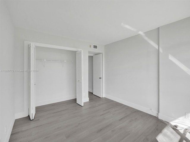 3700 Oaks Clubhouse Dr Unit 203, Pompano Beach, FL 33069 - unfurnished bedroom featuring wood finished floors, a closet, and baseboards