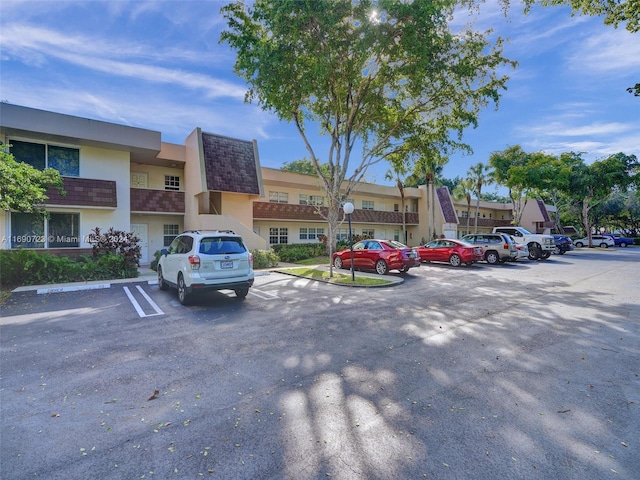 3700 Oaks Clubhouse Dr Unit 203, Pompano Beach, FL 33069 - view of building exterior with uncovered parking and a residential view