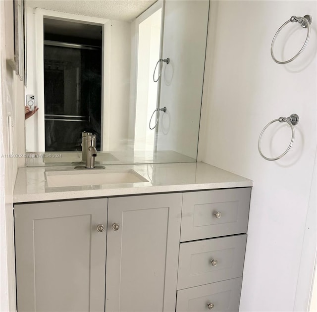 bathroom with vanity and a textured ceiling