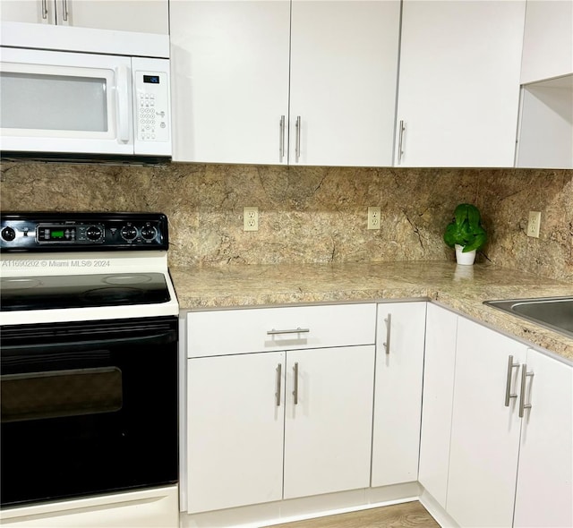 kitchen with light wood-type flooring, white cabinets, decorative backsplash, and electric range