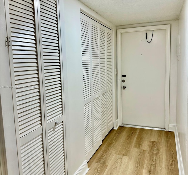 doorway to outside featuring light hardwood / wood-style floors and a textured ceiling