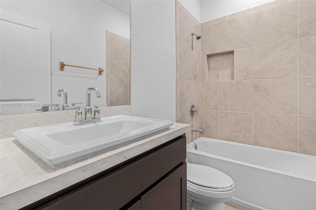 full bathroom with tiled shower / bath, vanity, and toilet