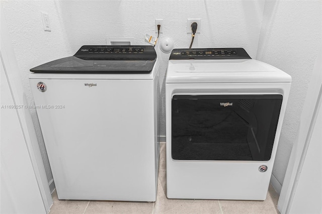 laundry area featuring washing machine and dryer and light tile patterned floors