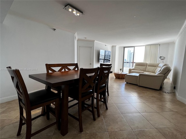 dining area with light tile patterned floors and crown molding