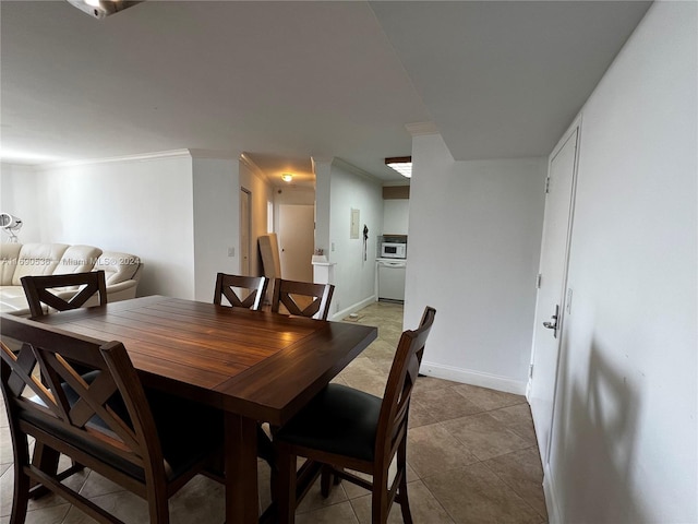 tiled dining area featuring crown molding