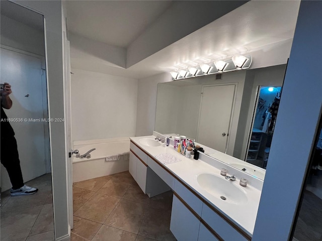 bathroom featuring a tub to relax in, vanity, and tile patterned flooring