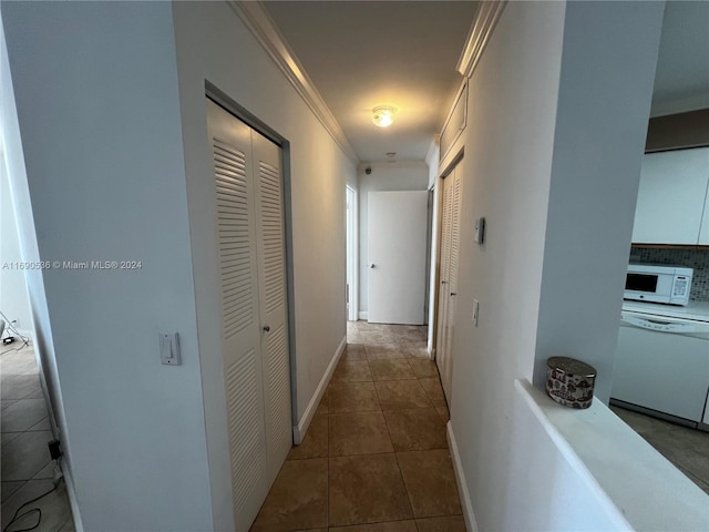 corridor featuring tile patterned floors and crown molding