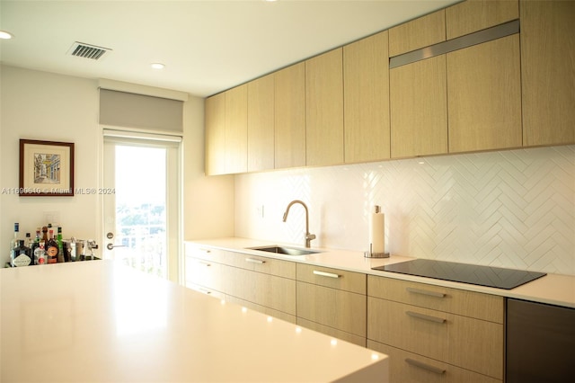 kitchen with tasteful backsplash, light brown cabinets, sink, and black electric stovetop