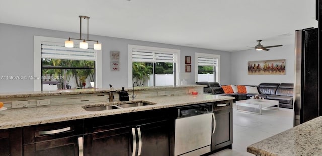 kitchen with light stone counters, hanging light fixtures, sink, ceiling fan, and appliances with stainless steel finishes