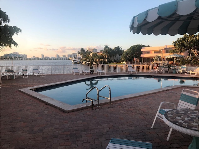 pool at dusk with a patio