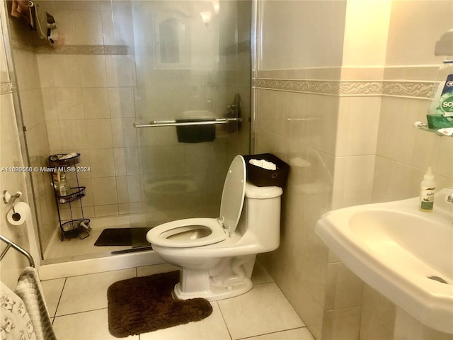 bathroom featuring tile walls, tile patterned floors, walk in shower, sink, and toilet