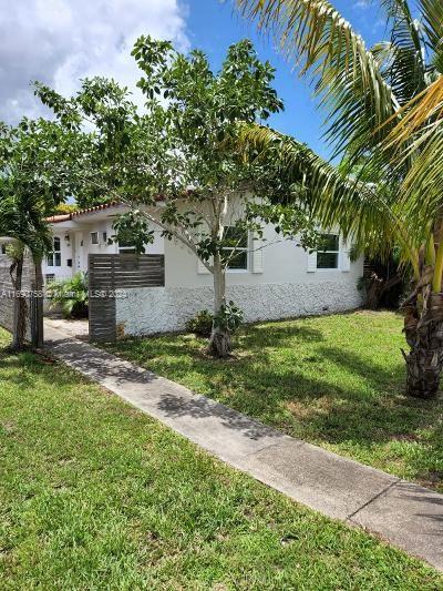 8960 NE 2nd Ave, El Portal, FL 33138 - view of side of property featuring a lawn and stucco siding