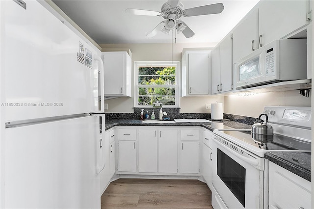 kitchen with sink, white appliances, light hardwood / wood-style flooring, ceiling fan, and white cabinets