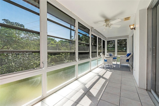 unfurnished sunroom with ceiling fan