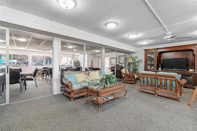 living room with a textured ceiling, ceiling fan, and carpet
