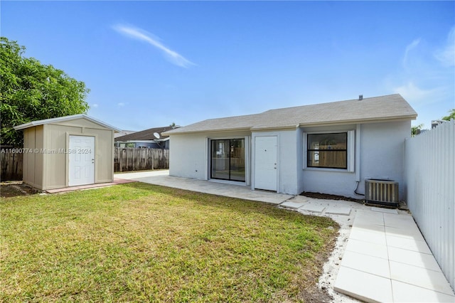 rear view of property with a shed, cooling unit, a lawn, and a patio