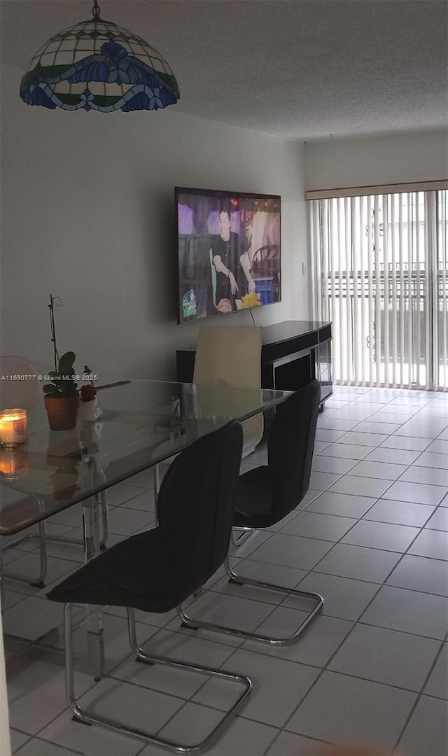 dining room featuring light tile patterned floors and a textured ceiling