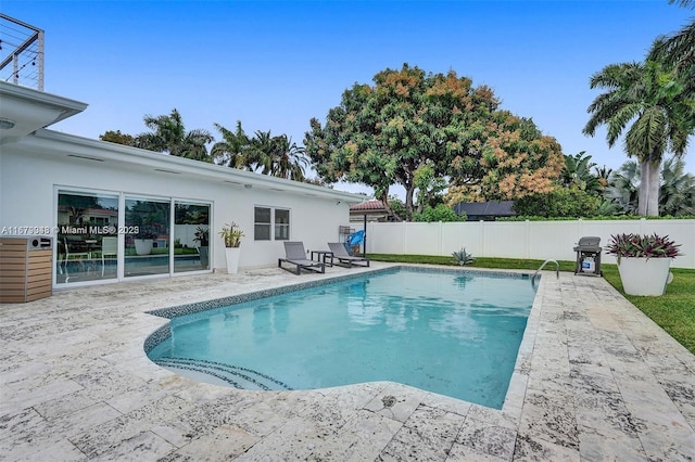 view of pool with area for grilling and a patio area