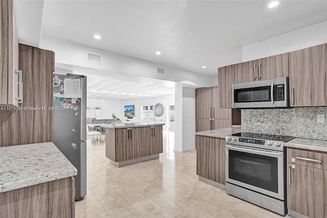 kitchen featuring backsplash, a center island, a kitchen bar, and stainless steel appliances