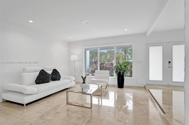 living room featuring beam ceiling and french doors