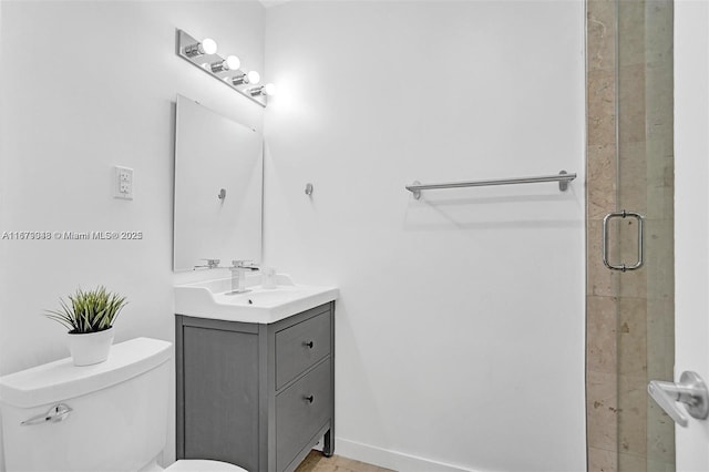 bathroom with a shower with door, vanity, and toilet