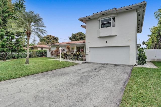 mediterranean / spanish house with a garage and a front yard