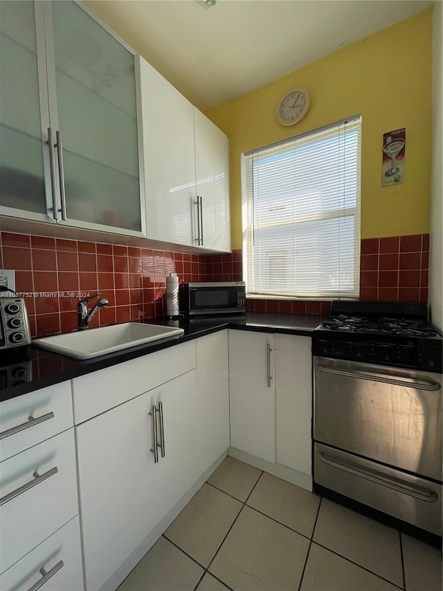 kitchen featuring light tile patterned floors, white cabinetry, sink, and appliances with stainless steel finishes