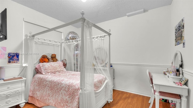 bedroom featuring wood-type flooring and a textured ceiling