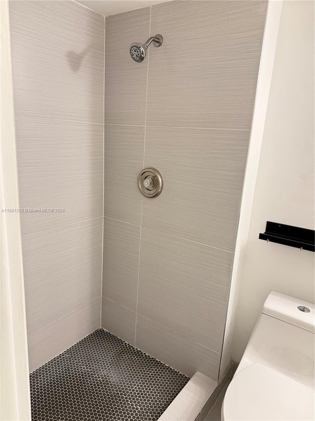 bathroom with tiled shower and toilet