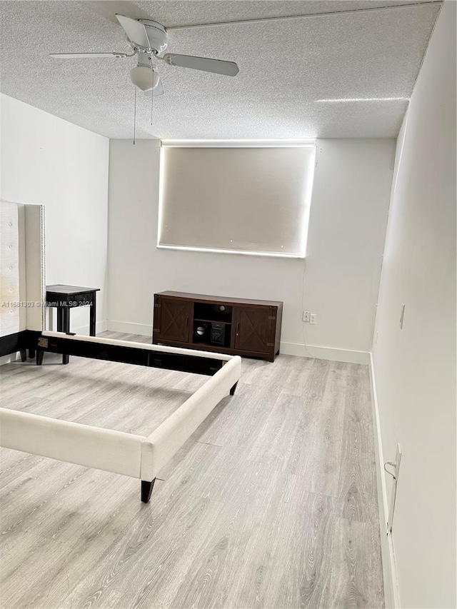 playroom with ceiling fan, wood-type flooring, and a textured ceiling