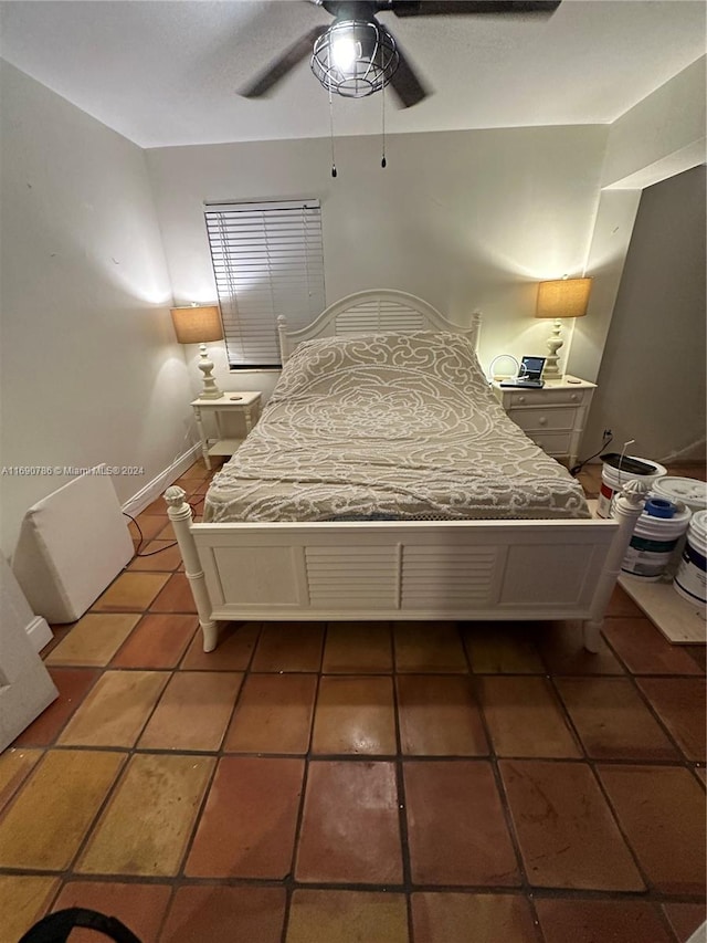 bedroom with ceiling fan and dark tile patterned flooring