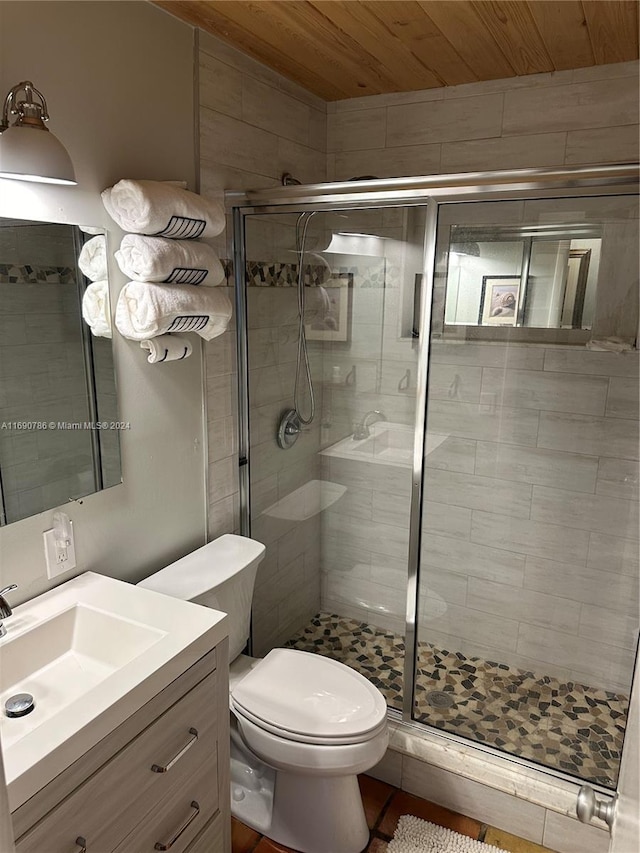 bathroom featuring vanity, toilet, a shower with shower door, and wood ceiling