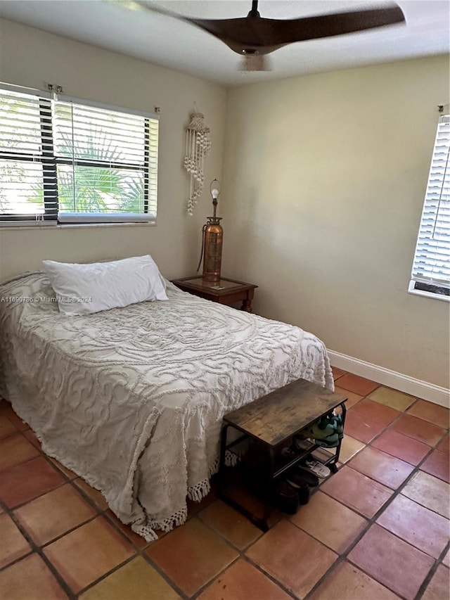 bedroom with multiple windows, ceiling fan, and tile patterned flooring