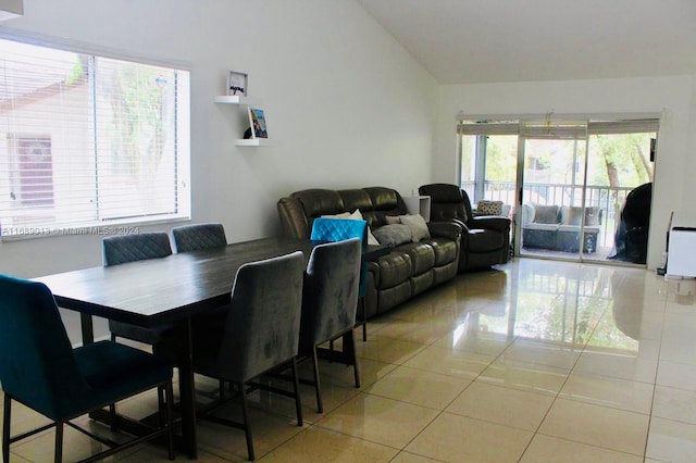 tiled dining room featuring lofted ceiling and a healthy amount of sunlight