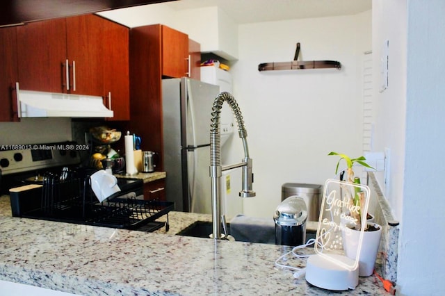 kitchen featuring stainless steel fridge and light stone counters