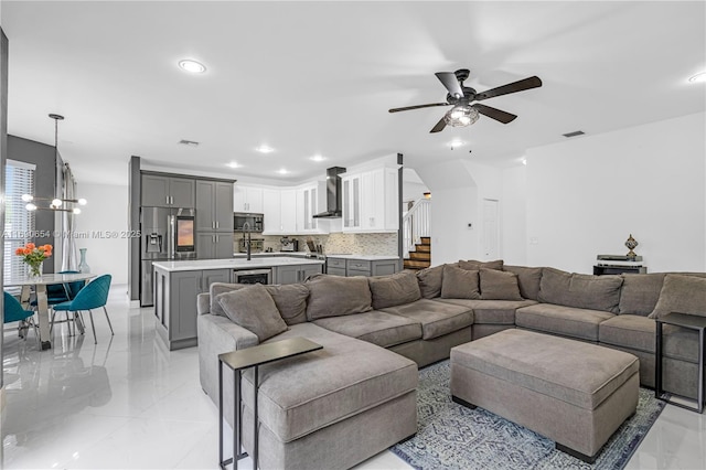 living room with ceiling fan with notable chandelier