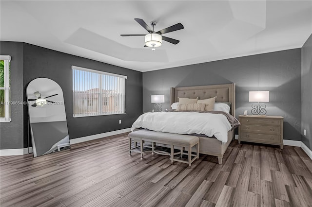 bedroom featuring a tray ceiling, ceiling fan, and hardwood / wood-style floors