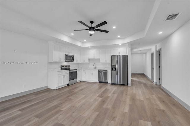 kitchen with appliances with stainless steel finishes, sink, light hardwood / wood-style floors, and white cabinets