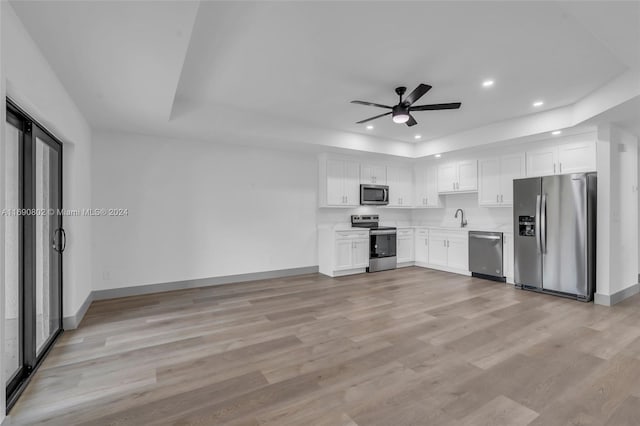 kitchen featuring white cabinets, sink, ceiling fan, light wood-type flooring, and appliances with stainless steel finishes